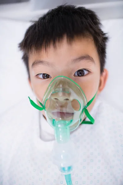 Niño paciente con máscara de oxígeno acostado en la cama del hospital —  Fotos de Stock