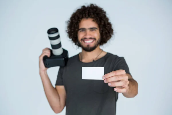 Fotógrafo mostrando cartão de visita em estúdio — Fotografia de Stock