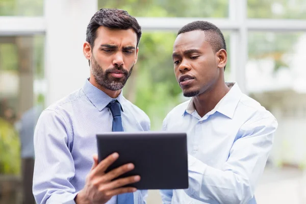 Business executives discussing over digital tablet — Stock Photo, Image