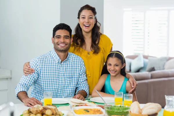 Daughter and parents having meal on table at home — Stock Photo, Image