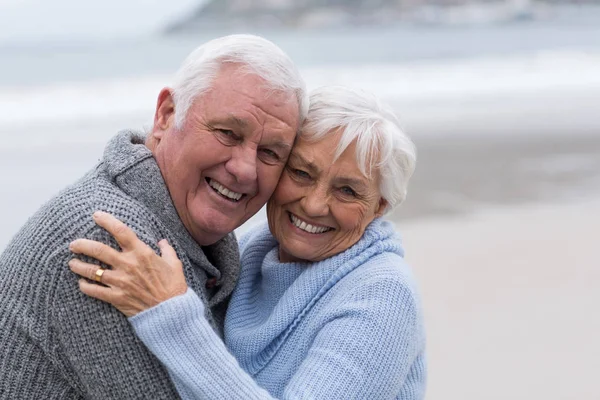 Äldre par stående tillsammans på stranden — Stockfoto