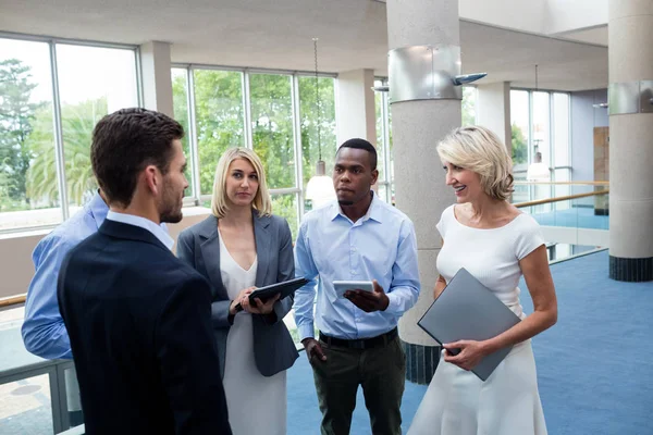 Dirigeants d'entreprises interagissant dans un hall de centre de conférence — Photo