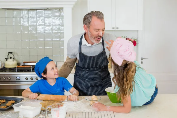Father and kids having fun while making dough in kitchen — Stock Photo, Image