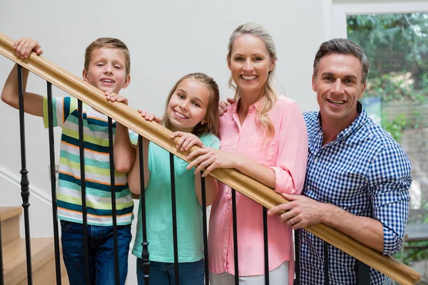 Pais e filhos em pé na escada em casa — Fotografia de Stock