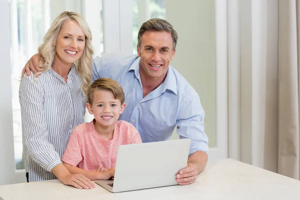Parents et fils utilisant un ordinateur portable à la maison — Photo
