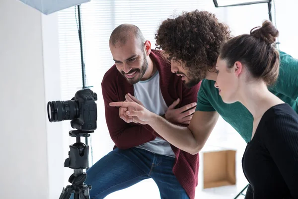 Photographe et collègues regardant les photos — Photo