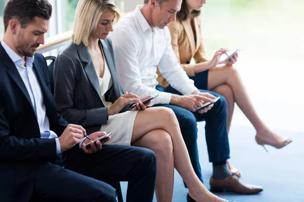 Ejecutivos de negocios usando teléfono móvil — Foto de Stock