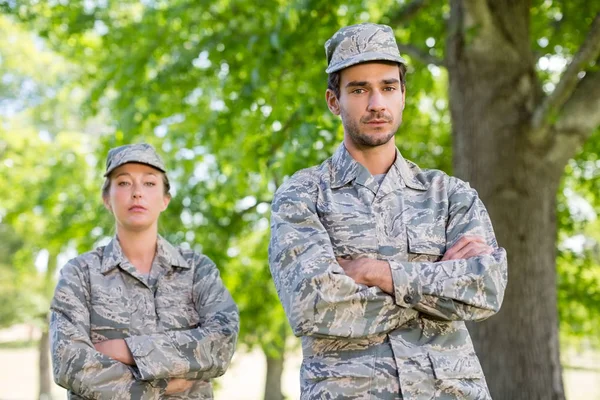 Portrait d'un couple militaire debout les bras croisés dans le parc — Photo