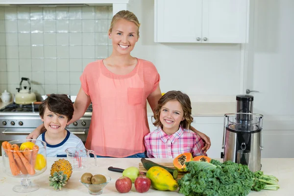 Portrait d'une mère heureuse et de ses deux enfants debout dans la cuisine — Photo