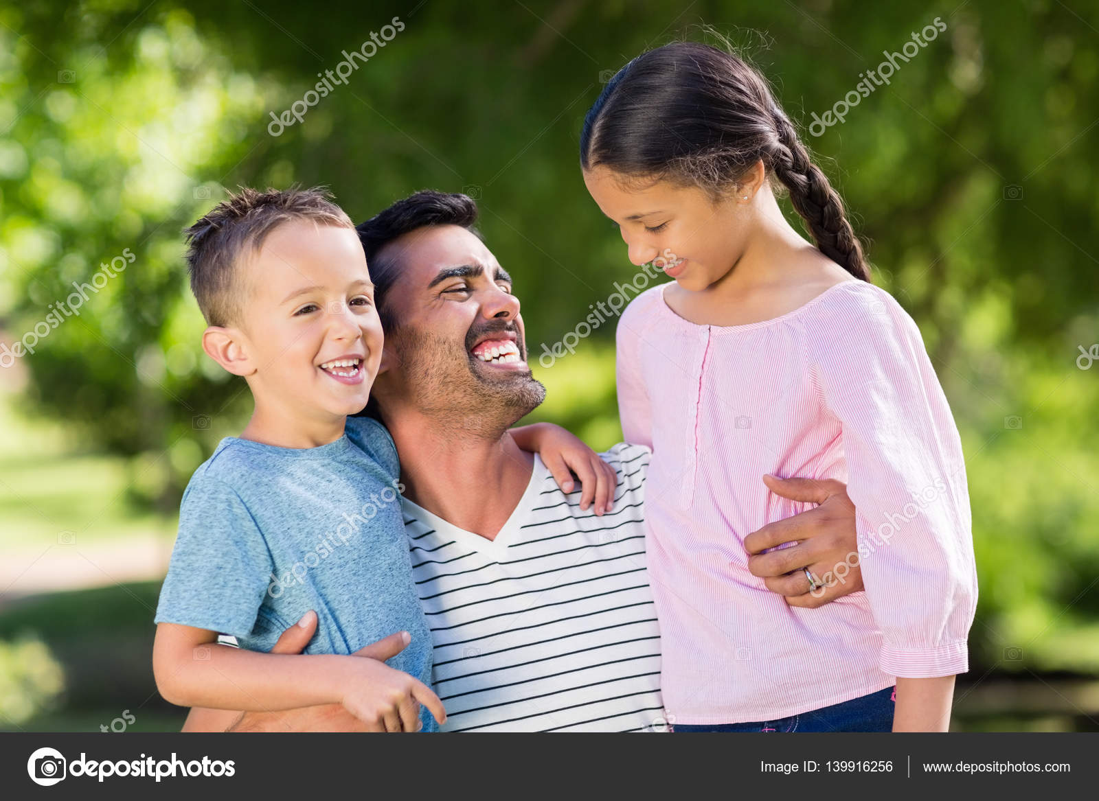 father-having-fun-with-his-son-and-daughter-in-park-stock-photo