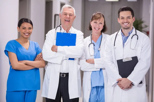 Портрет улыбающихся врачей и медсестры, стоящих со скрещенными руками — стоковое фото