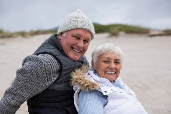 Feliz pareja de ancianos sentados juntos en la playa —  Fotos de Stock