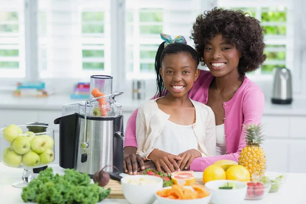 Portret van de moeder en dochter permanent in keuken — Stockfoto