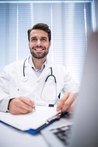 Doctor masculino escribiendo en portapapeles —  Fotos de Stock