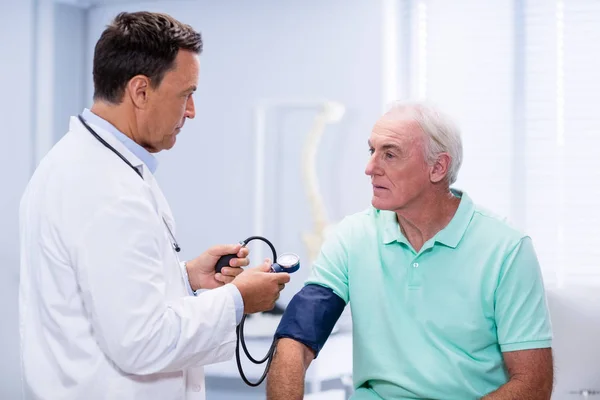 Médico verificando a pressão arterial de um paciente — Fotografia de Stock