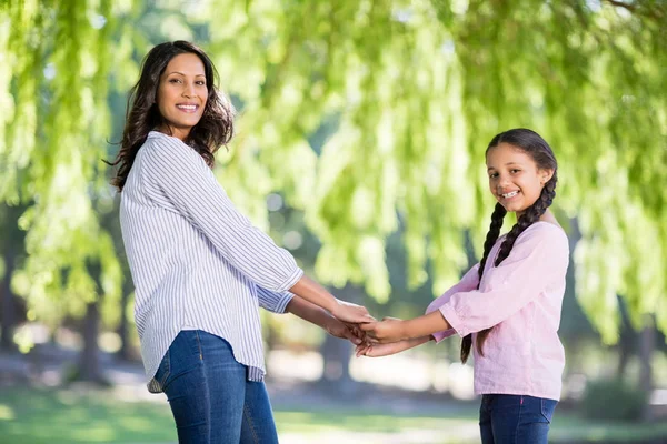 Madre cogida de la mano de su hija en el parque — Foto de Stock