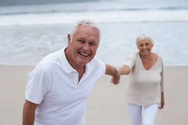 Senior para wspólna zabawa na plaży — Zdjęcie stockowe