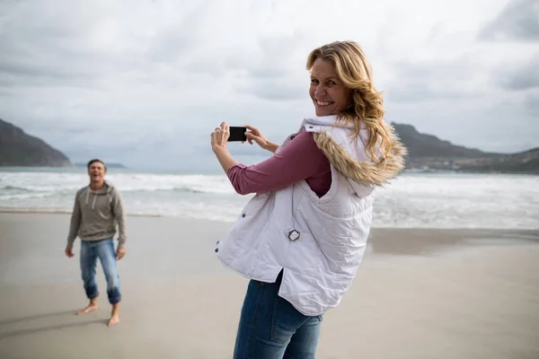 Portrait of mature woman clicking a picture of man — Stock Photo, Image