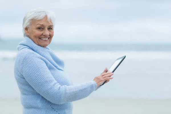 Donna anziana utilizzando tavolo digitale sulla spiaggia — Foto Stock