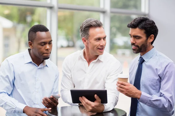 Dirigenti aziendali discutono su tablet digitale — Foto Stock