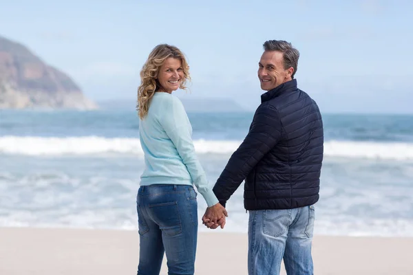 Portret van paar staande met bedrijf handen op het strand — Stockfoto