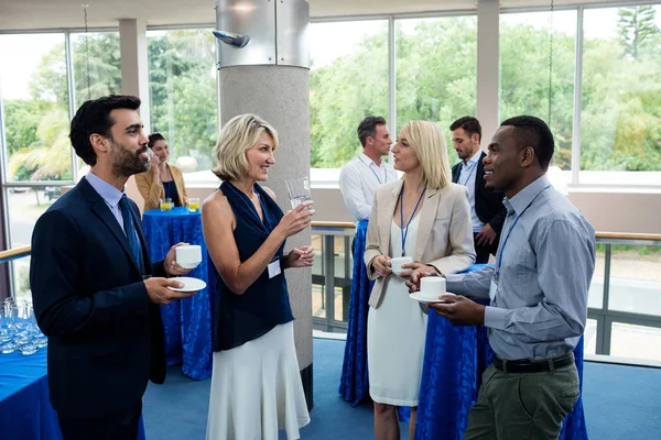 Dirigeants d'entreprise interagissant les uns avec les autres tout en prenant un café — Photo