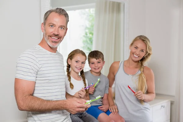 Porträtt av föräldrar och barn borsta tänderna i badrum — Stockfoto