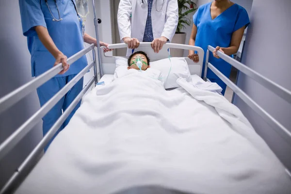 Doctors pushing emergency stretcher bed in corridor — Stock Photo, Image