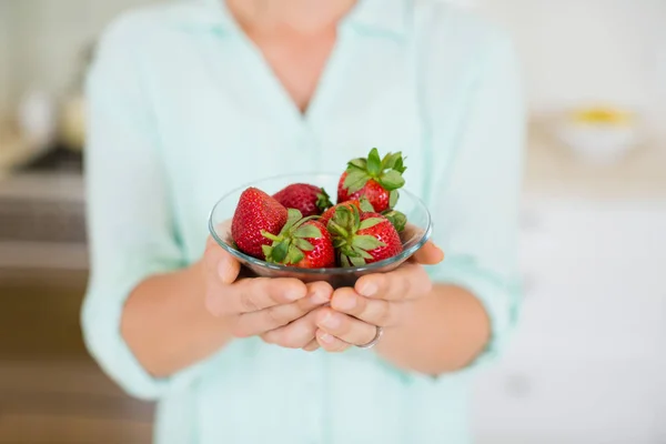 Beautiful woman holding glass of strawberry in kitchen — Stock Photo, Image