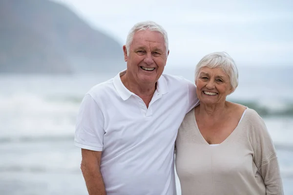 Retrato de pareja de ancianos de pie juntos en la playa — Foto de Stock