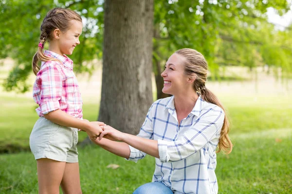 Porträtt av en mor som håller händerna på hennes dotter i park — Stockfoto