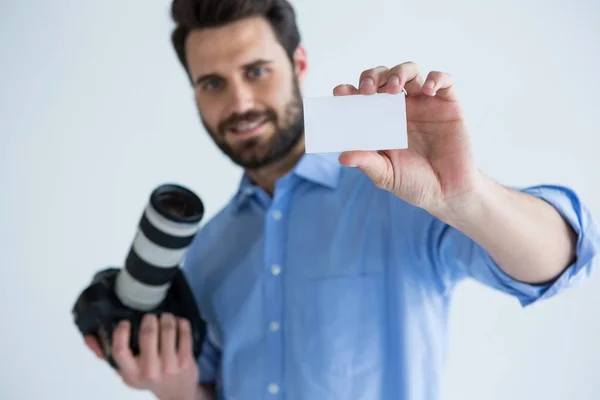 Fotógrafo mostrando cartão de visita em estúdio — Fotografia de Stock