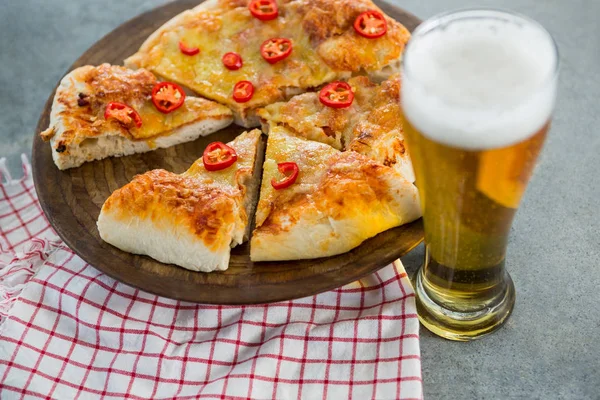 Trozos de pizza italiana servidos con un vaso de cerveza — Foto de Stock
