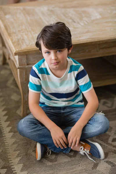 Portret van jongen zitten in woonkamer — Stockfoto