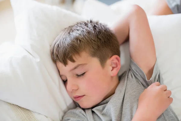 Niedlichen Jungen schlafen auf Bett im Schlafzimmer — Stockfoto