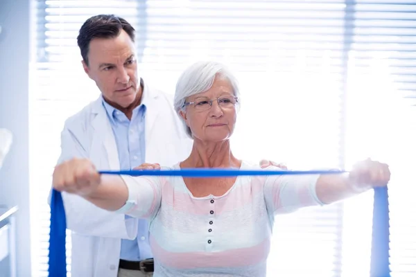 Male physiotherapist giving shoulder massage to senior woman — Stock Photo, Image
