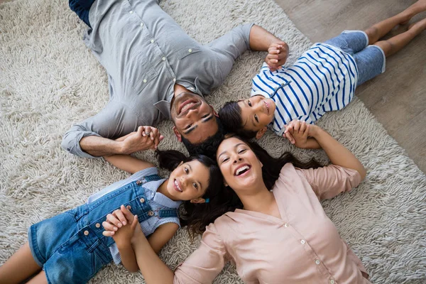 Porträtt av lyckliga föräldrar och barn liggande på matta — Stockfoto