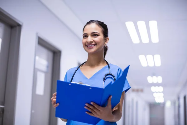 Женщина-врач держит файл в коридоре — стоковое фото