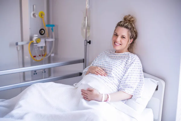 Retrato de la mujer embarazada relajándose en la cama del hospital — Foto de Stock