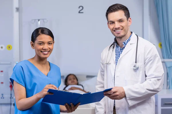 Porträt einer lächelnden Krankenschwester und eines Arztes mit Klemmbrett — Stockfoto