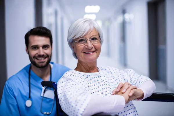 Portret lekarza i pacjentki starszy uśmiechający się na korytarzu — Zdjęcie stockowe