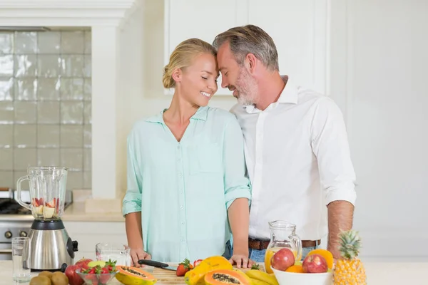 Casal sorridente que romancia na cozinha — Fotografia de Stock