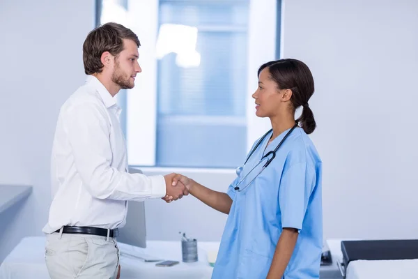 Läkare och patient skakar hand — Stockfoto