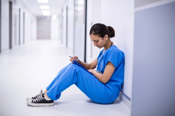 Médica mulher ler relatórios no corredor — Fotografia de Stock