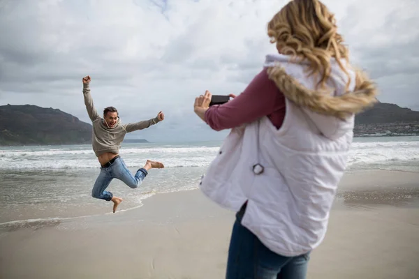 Mature woman clicking a picture of man — Stock Photo, Image