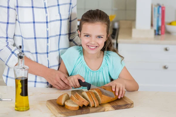 母亲帮助女儿切片面包面包 — 图库照片
