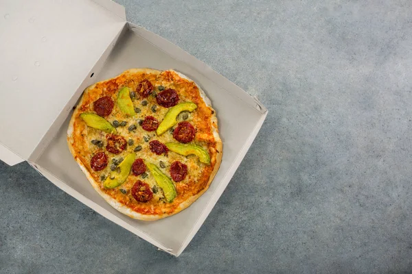 Italiaanse pizza geserveerd in een geopende doos — Stockfoto