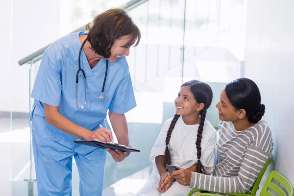 Verpleegkundige een medisch rapport met vrouw en patiënt bespreken — Stockfoto