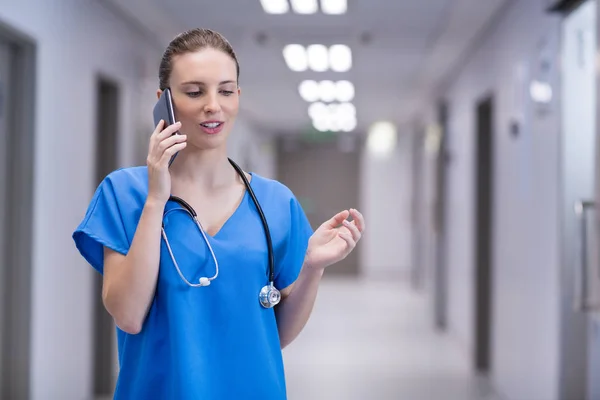 Médecin femme parlant sur téléphone portable dans le couloir — Photo