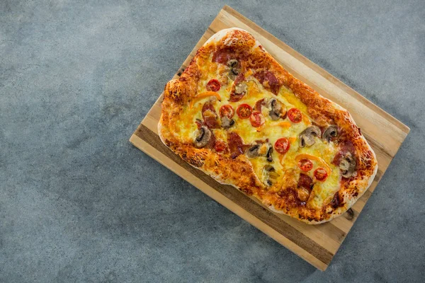 Italienische Pizza auf einem Schneidebrett serviert — Stockfoto